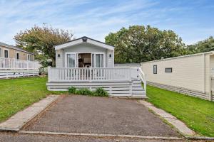 Casa blanca con porche en un patio en Artisan Lodge Shorefield Country Park Downton Lymington en Lymington