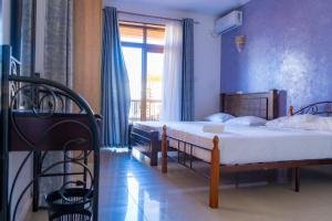 1 dormitorio con 2 camas y ventana en Home away from home, 5 Bedroom Villa, Bustani Close, Nyali Beach, en Mombasa