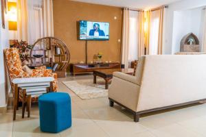 ein Wohnzimmer mit einem Sofa und Stühlen in der Unterkunft Home away from home, 5 Bedroom Villa, Bustani Close, Nyali Beach in Mombasa