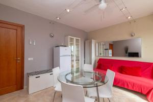 een woonkamer met een glazen tafel en een rode bank bij A 101 Puntavilla Mare in La Maddalena