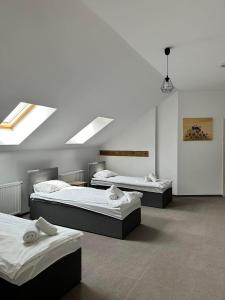 3 camas en una habitación con techo en Folwark Matecznik - Dworek, en Sęzinko
