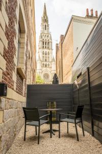 stół i 2 krzesła na balkonie z budynkiem w obiekcie L'eSPAce détente w mieście Valenciennes