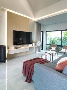 a living room with a couch and a large television at Harmonic HuaHin Pool Villa-3BR, 3 Bath, 2 Kitchen in Hua Hin +38 photos
