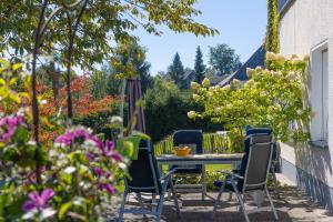 a patio with a table and chairs and flowers at Ferienwohnung Trapp in Winterberg
