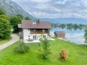 a house on a hill next to a lake at Seegut Steeg am Hallstättersee in Bad Goisern