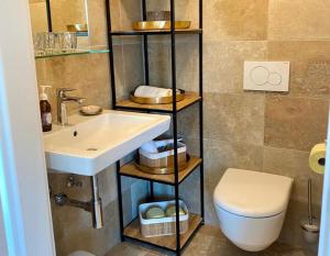 a bathroom with a white sink and a toilet at Seegut Steeg am Hallstättersee in Bad Goisern