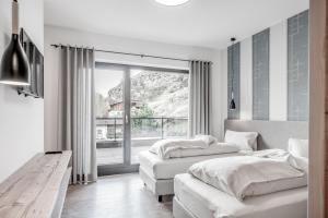 a bedroom with two beds and a large window at Corso Living in Sölden