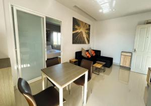 uma sala de estar com uma mesa e um sofá em Zada Residence em Nakhon Ratchasima