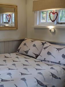 GrimstonにあるKing Nutkin Shepherds Hutの寝室に枕が2つ置かれたベッド