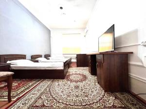 a room with two beds and a flat screen tv at Hello Hostel in Samarkand