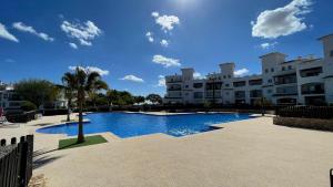 a large swimming pool in front of a building at Golf View Apartment in Sucina
