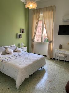 um quarto com uma cama grande e uma janela em CASA ARISTON em Sassari