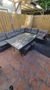a patio with a couch and a glass table at Eyre Square Lane Budget Rooms in Galway