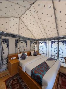 ein Schlafzimmer mit einem Bett in einem Zelt in der Unterkunft Sam dunes desert safari camp in Jaisalmer