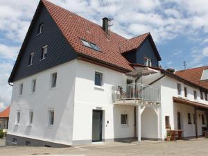 ein weißes Haus mit schwarzem Dach in der Unterkunft Landgasthof Lamm Ferienwohnungen in Burladingen