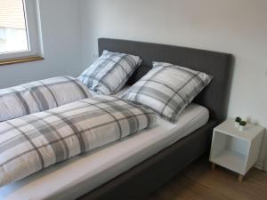 a bed with two pillows and a table at Landgasthof Lamm Ferienwohnungen in Burladingen