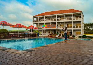 a person is cleaning a swimming pool in front of a hotel at Ponta View Hotel in Ponta do Ouro