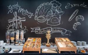 a chalkboard wall with drawings of a chef and pastries at Aqua Pedra Dos Bicos Design Beach Hotel - Adults Only in Albufeira