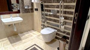 y baño con aseo y lavamanos. en Bayat Hotel, en Khamis Mushayt