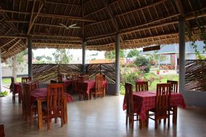 a restaurant with tables and chairs with red table cloth at Mapeni Lodge in Kidenge