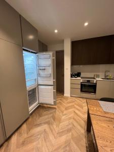 een lege keuken met een open koelkast en houten vloeren bij Natali's luxury apartment in Strovolos