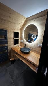 een badkamer met een wastafel en een ronde spiegel bij Chalet Le 36 Le Mont Dore 6pers in Le Mont-Dore