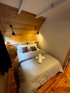 een slaapkamer met een groot wit bed in een kamer bij Chalet Le 36 Le Mont Dore 6pers in Le Mont-Dore