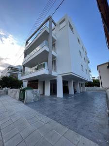 een wit appartementencomplex met een parkeerplaats bij Natali's luxury apartment in Strovolos