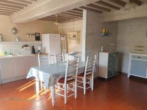 a kitchen with a table and chairs in a room at Petite maison au calme à Anost in Anost