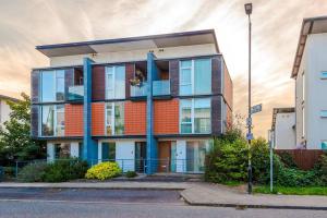 an apartment building with blue columns on a street at Tranquil 3 Bedroom Manchester Retreat With Parking in Manchester