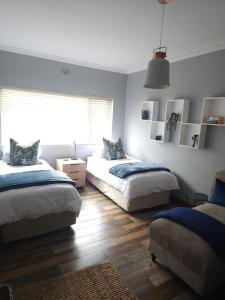 a bedroom with two beds and a window in it at Cape Town, Sea Point, Beautiful 2 Bedroom Apartment @Tucked Away in Cape Town