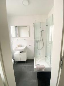 a white bathroom with a shower and a sink at Balcony-Appartement in Bielefeld