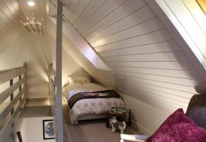 a small bedroom with a bed in a attic at Smithy Cottage in Strathdon