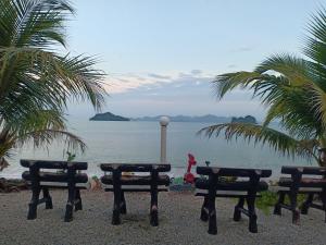 a picnic table on the beach with a view of the ocean at Langkawi Primrose Seaview in Tanjung Rhu 