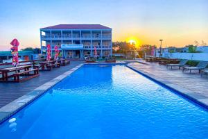 a large swimming pool with benches and a building at Ponta View Hotel in Ponta do Ouro