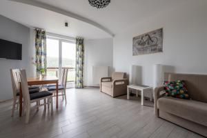 a living room with a couch and a table at Willa z gwarantowanym widokiem na góry Aleksander Panorama in Świeradów-Zdrój