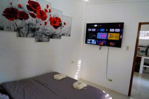 a bedroom with a bed and a tv on the wall at W&B 1 BDR COZY APARTMENT in Panglao