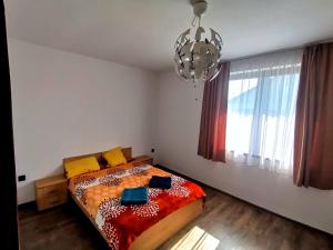a bedroom with a bed and a chandelier at Party House in Tunari