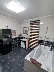 a large bathroom with a tub and a sink at Party House in Tunari