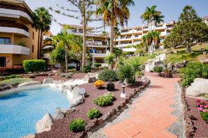 Un complejo con piscina y un edificio. en Modern apartment in Golf del Sur, AC237, tempered pool and ocean view, en San Miguel de Abona