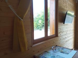 Habitación con 2 ventanas en una pared de madera. en Gîte du Chalet - Le studio en pleine nature, 