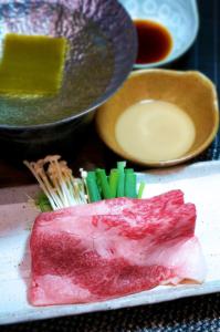 a plate of food with meat and vegetables and sauce at Sannouzan Onsen Zuisenkyo in Ichinoseki