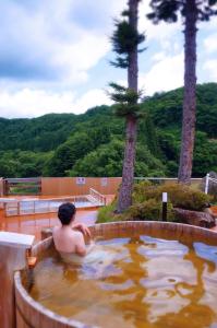 a man in a jacuzzi in a hot tub at Sannouzan Onsen Zuisenkyo in Ichinoseki