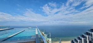 a swimming pool on top of a building next to the ocean at Apec Mandala Cham Bay Mũi Né in Mui Ne