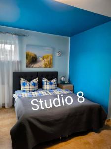 a blue bedroom with a bed with a subivo sign on it at Willa Mariolina in Świnoujście