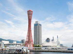 神戶的住宿－KAMENOI HOTEL Arima，一座高塔,毗邻一座城市,拥有建筑