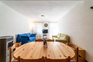 - un salon avec une table en bois et un canapé bleu dans l'établissement Casa Vallazza, à Alleghe