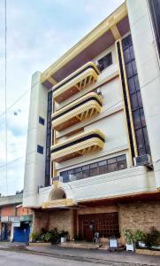 a tall white building with yellow accents at PHELA GRANDE HOTEL in General Santos