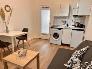 eine Küche und ein Wohnzimmer mit einem Tisch und einem Herd in der Unterkunft Modernes Appartement Nähe City in Dortmund