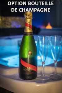 a bottle of champagne on a table with two glasses at L'eSPAce détente in Valenciennes